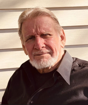 Headshot photo of an older man with gray hair and a trimmed white beard