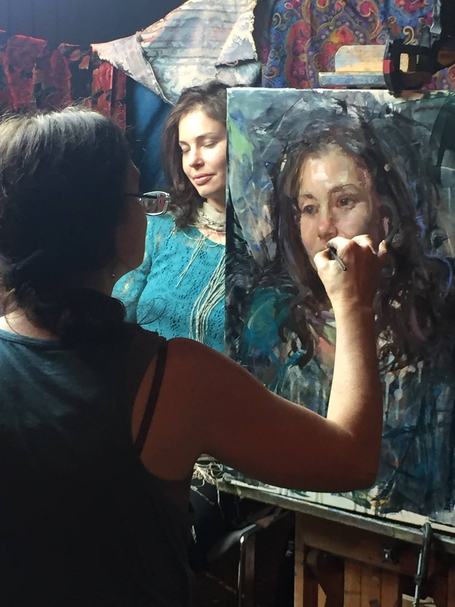 artist at easel painting model in studio